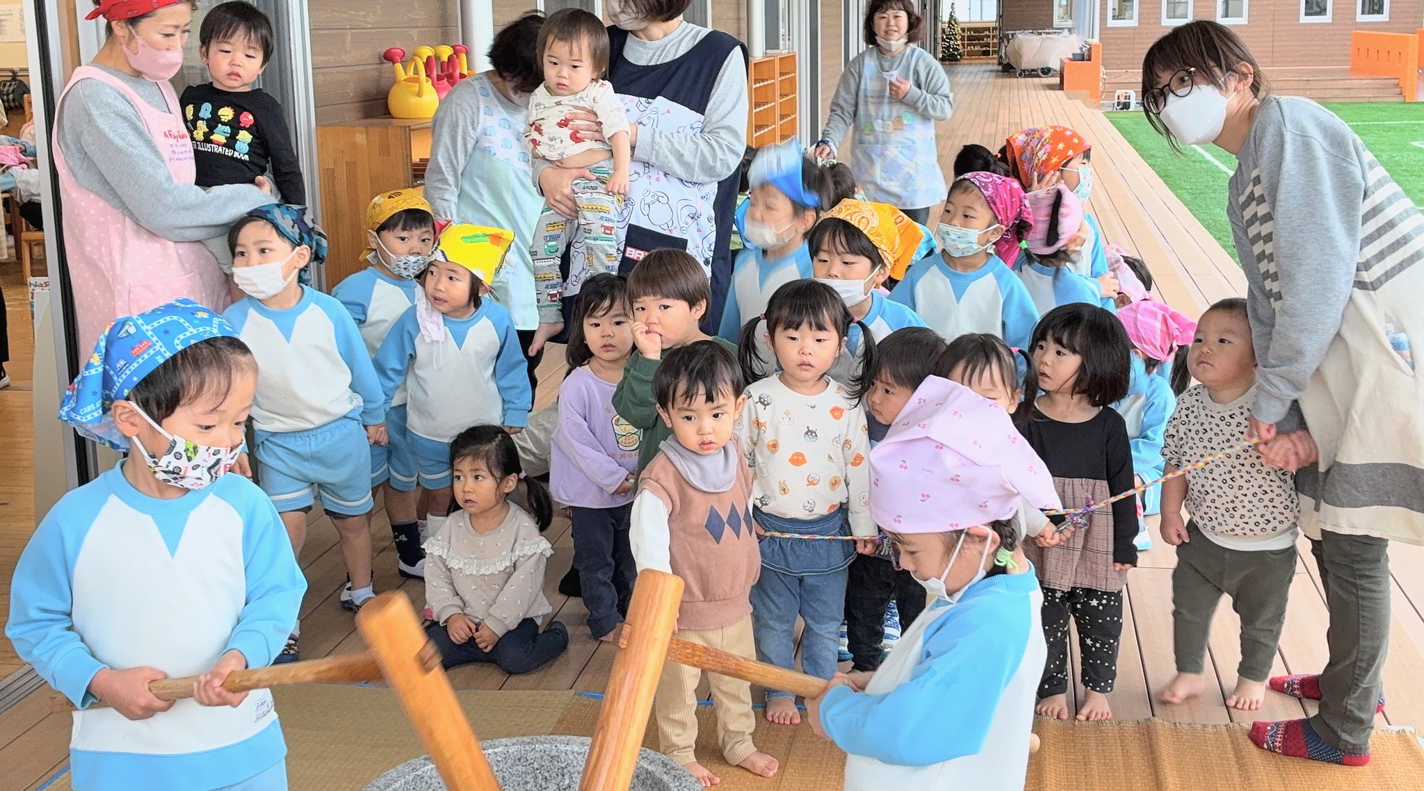 みんなで囲んで餅つきをする子どもたち