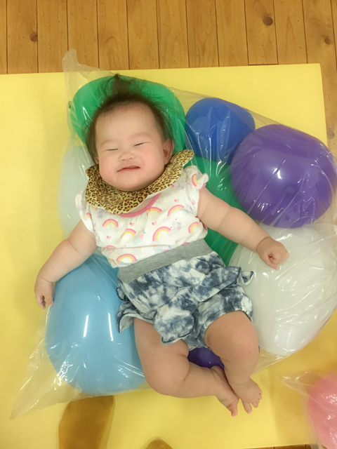 クッションの上で笑う赤ちゃん