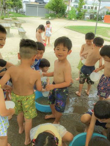 園庭で水遊びをする子どもたち